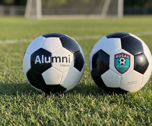 Alumni Classic soccer ball and co-branded team-crest ball on grass